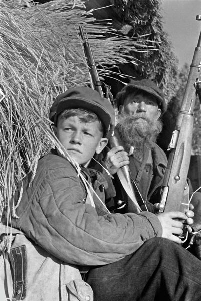 Партизаны в дозоре. 13-летний Леня Федоров и колхозник колхоза Борец И.В.Гришин, вступивший в партизанский отряд, несмотря на преклонный возраст Партизаны в дозоре. 13-летний Леня Федоров и колхозник колхоза Борец И.В.Гришин, вступивший в партизанский отряд, несмотря на преклонный возраст