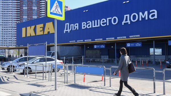 Женщина идет мимо магазина IKEA Женщина идет мимо магазина IKEA