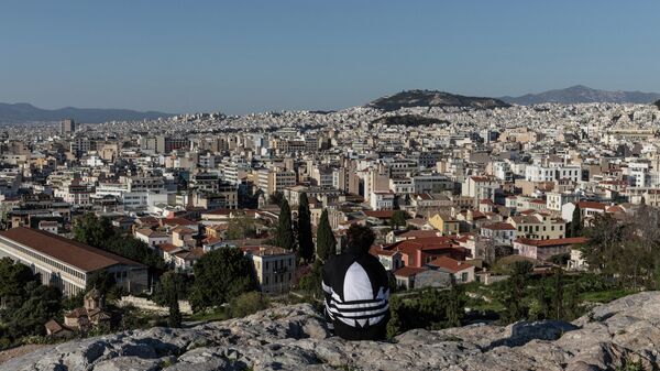 Молодой человек на холме Акрополь в Афинах