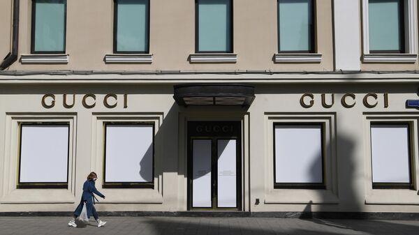 Девушка в защитной маске проходит мимо витрин закрытого магазина Gucci на улице Петровка в Москве Девушка в защитной маске проходит мимо витрин закрытого магазина Gucci на улице Петровка в Москве