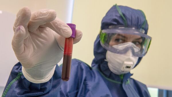 Сотрудник в лаборатории с тестом на антитела к коронавирусу