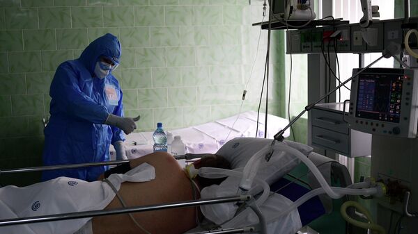 Врач и пациент в отделении реанимации и интенсивной терапии городской клинической больницы имени В. В. Виноградова, переоснащенной для лечения пациентов с COVID-19 Врач и пациент в отделении реанимации и интенсивной терапии городской клинической больницы имени В. В. Виноградова, переоснащенной для лечения пациентов с COVID-19