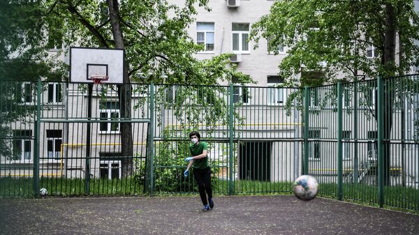 Подросток в защитной маске на спортивной площадке в одном из московских дворов во время режима самоизоляции жителей Подросток в защитной маске на спортивной площадке в одном из московских дворов во время режима самоизоляции жителей