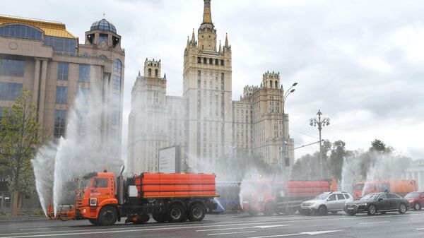 Автомобили коммунальных служб во время дезинфекции проезжей части дорог в Москве Автомобили коммунальных служб во время дезинфекции проезжей части дорог в Москве