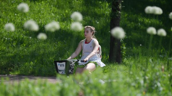 Девушка катается на велосипеде в Центральном парке культуры и отдыха имени Горького в Москве Девушка катается на велосипеде в Центральном парке культуры и отдыха имени Горького в Москве