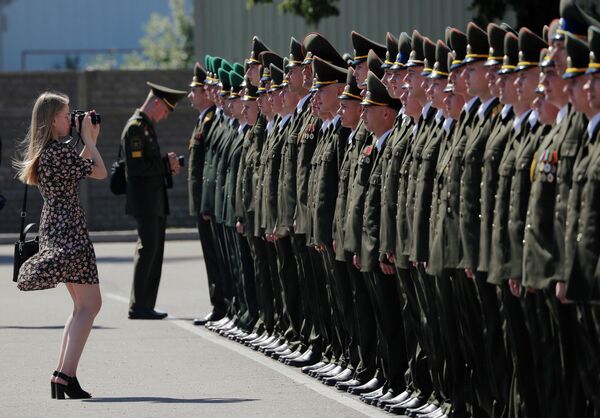 Женщина фотографирует выпускников Военной академии Беларуси в Минске Женщина фотографирует выпускников Военной академии Беларуси в Минске