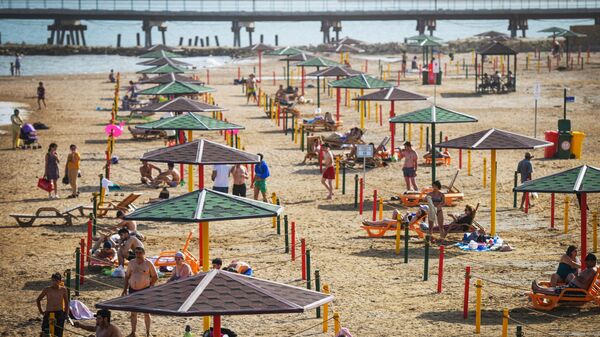 Люди отдыхают на пляже в Баку Люди отдыхают на пляже в Баку