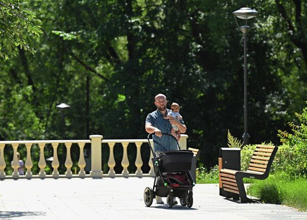 Мужчина гуляет с ребенком в парке Сад будущего в Москве Мужчина гуляет с ребенком в парке Сад будущего в Москве