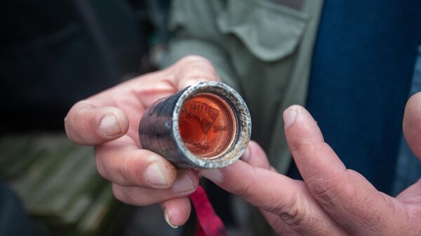 Мужчина держит в руке кассетный (кластерный) боеприпас, найденный после ночных обстрелов Степанакерта Мужчина держит в руке кассетный (кластерный) боеприпас, найденный после ночных обстрелов Степанакерта