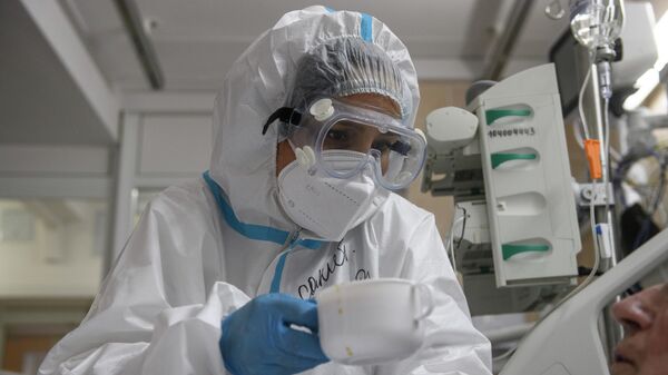 Медицинский работник оказывает помощь пациенту с COVID-19 в отделении реанимации и интенсивной терапии городской клинической больнице № 52 в Москве Медицинский работник оказывает помощь пациенту с COVID-19 в отделении реанимации и интенсивной терапии городской клинической больнице № 52 в Москве