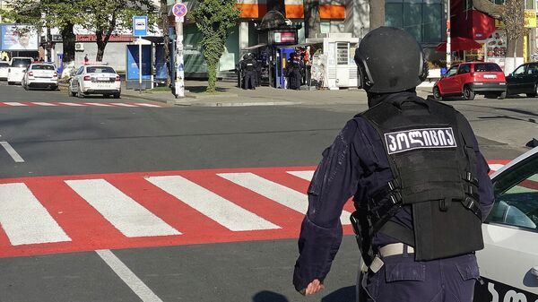 Полицейский возле филиала Банка Грузии в центре Зугдиди, где вооруженный мужчина захватил заложников Полицейский возле филиала Банка Грузии в центре Зугдиди, где вооруженный мужчина захватил заложников