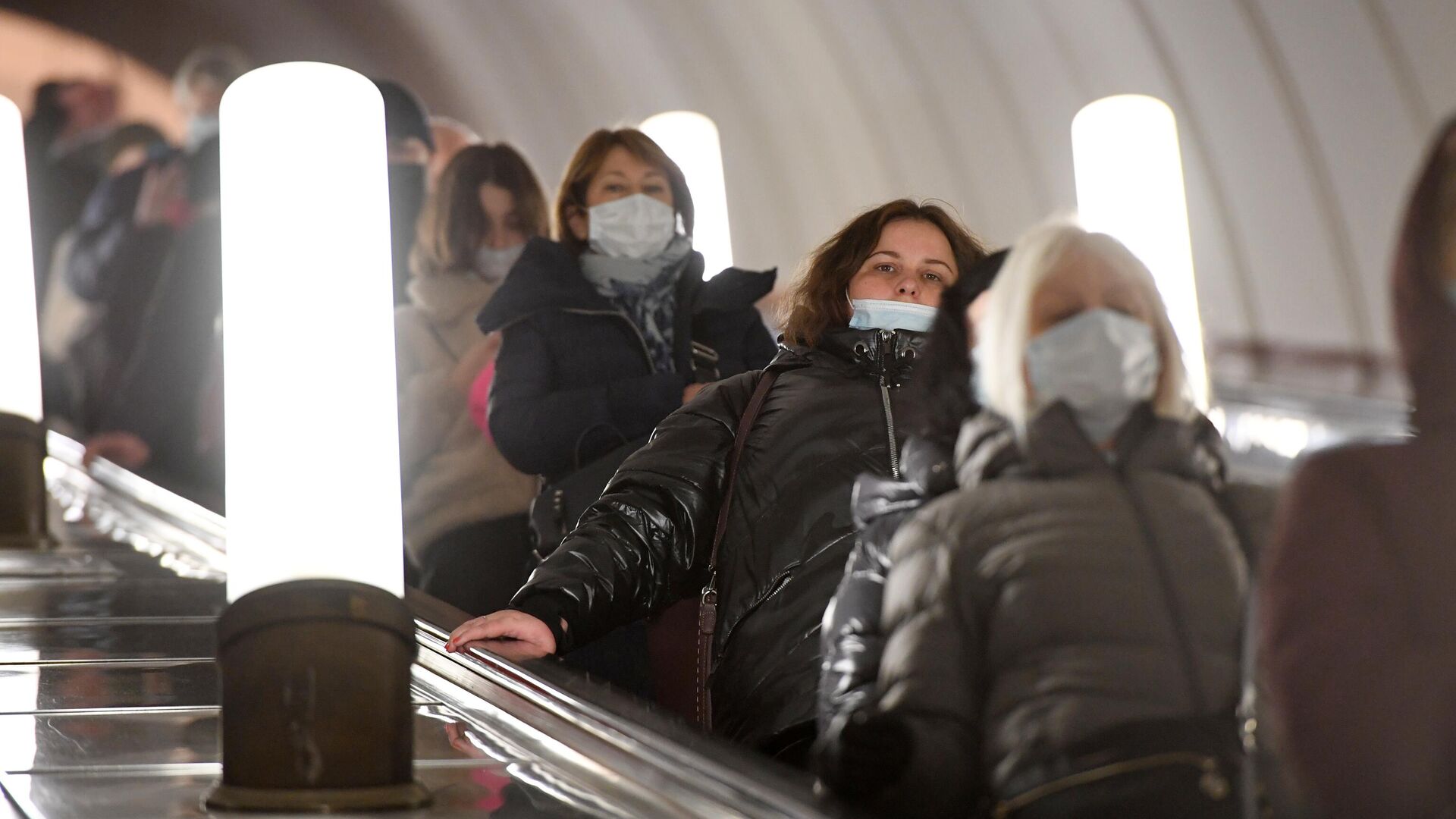 Стресс россиян. Эпидемия гриппа 2022. Девушка в маске на эскалаторе. Эпидемия гриппа 2022 в России.