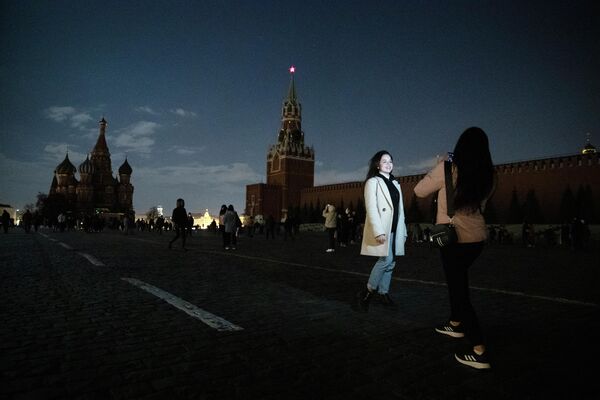 Девушки фотографируются на Красной площади в Москве во время экологической акции Час Земли Девушки фотографируются на Красной площади в Москве во время экологической акции Час Земли