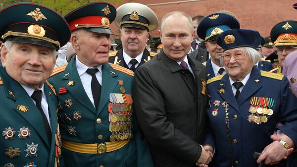 Президент РФ Владимир Путин фотографируется с ветеранами после церемонии возложения цветов к Вечному огню у Могилы Неизвестного Солдата в Александровском саду Президент РФ Владимир Путин фотографируется с ветеранами после церемонии возложения цветов к Вечному огню у Могилы Неизвестного Солдата в Александровском саду