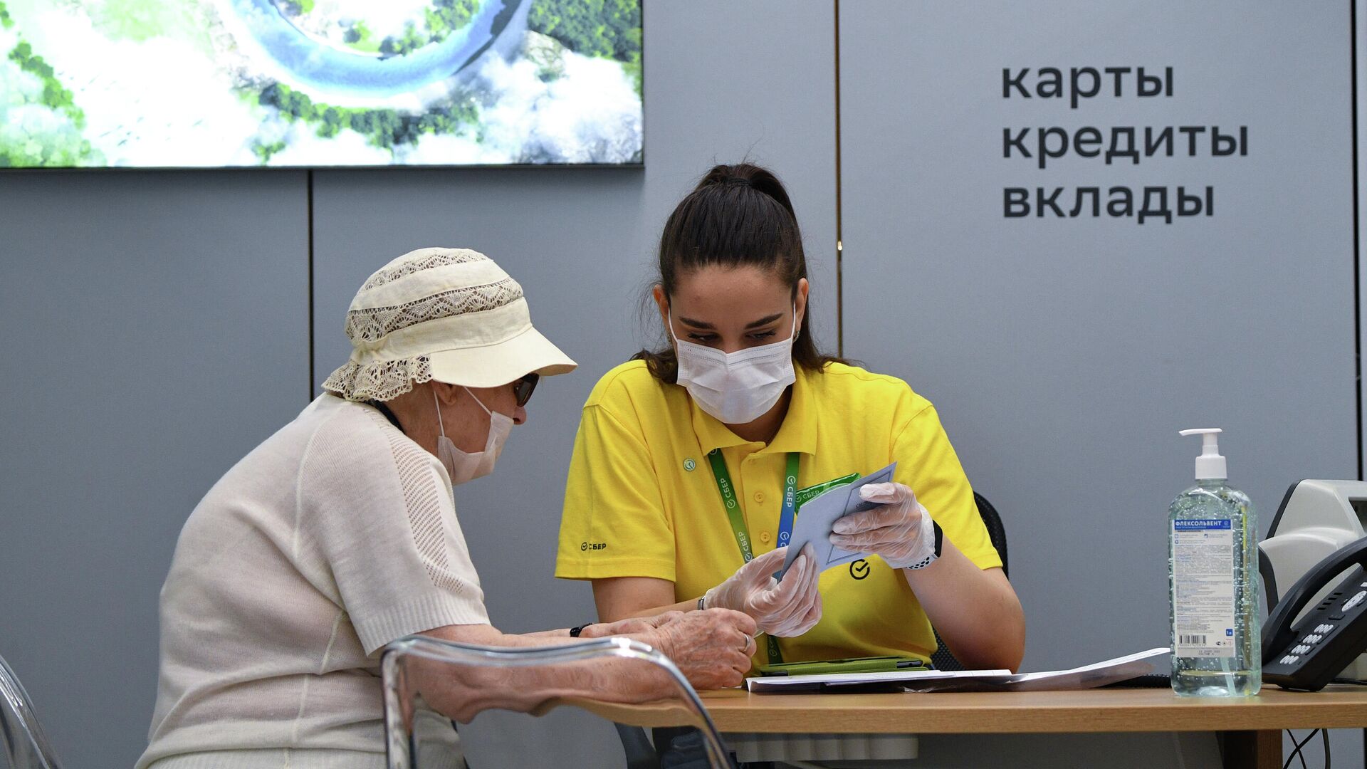 Сотрудница офиса Сбербанка нового формата, открывшегося на Красном проспекте в Новосибирске, во время работы с клиентом Сотрудница офиса Сбербанка нового формата, открывшегося на Красном проспекте в Новосибирске, во время работы с клиентом - РИА Новости, 1920, 21.07.2021
