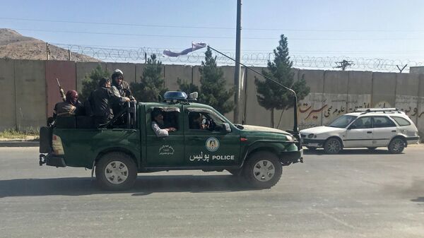 Боевики Талибана* едут на полицейской машине в Кабуле, Афганистан