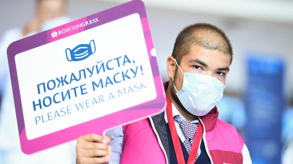 Волонтер с информационной табличкой на выставочной экспозиции в рамках Восточного экономического форума во Владивостоке