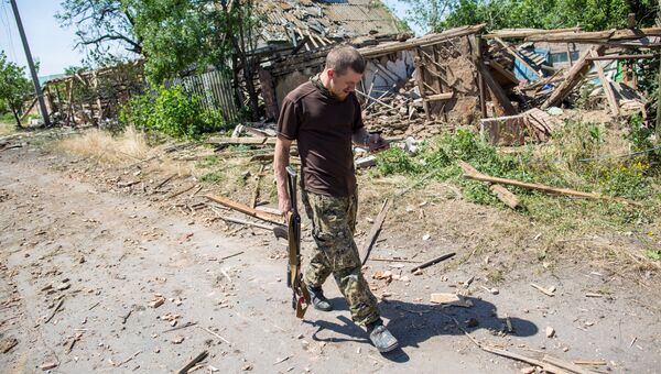 Боец народного ополчения у разрушенного артиллерийскими и авиаударами дома в поселке Семеновка Боец народного ополчения у разрушенного артиллерийскими и авиаударами дома в поселке Семеновка