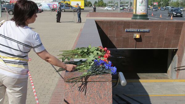 Женщина возлагает цветы у пешеходного перехода станции метро Парк победы, архивное фото Женщина возлагает цветы у пешеходного перехода станции метро Парк победы, архивное фото