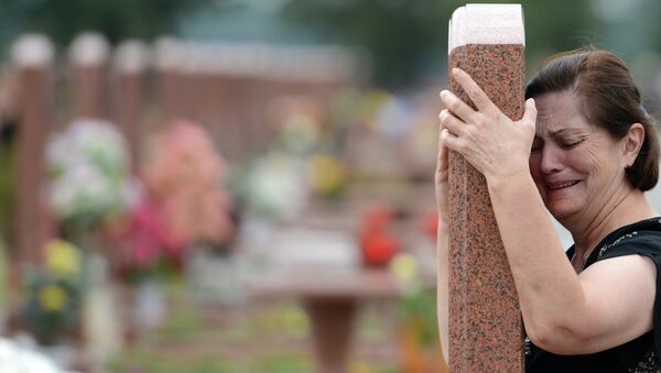 Женщина плачет на мемориальном кладбище Город ангелов в Беслане. Архивное фото Женщина плачет на мемориальном кладбище Город ангелов в Беслане. Архивное фото