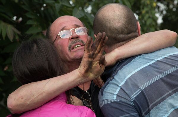 Мужчина обнимает своих родственников после обстрела в Донецке Мужчина обнимает своих родственников после обстрела в Донецке