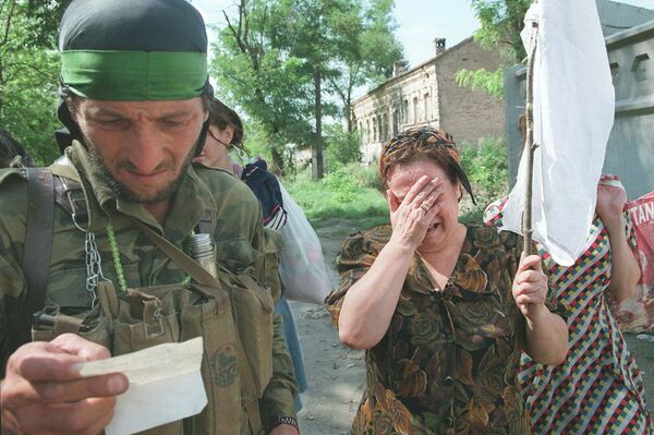 Чеченский боевик проверяет бумаги женщины идущей в Грозный Чеченский боевик проверяет бумаги женщины идущей в Грозный