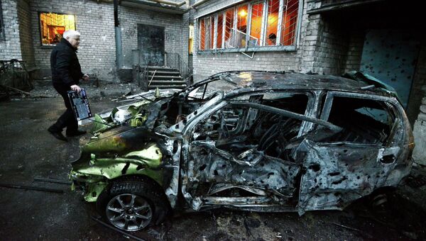 Сгоревшая автомашина у пострадавшего от обстрела жилого многоэтажного дома в Донецке Сгоревшая автомашина у пострадавшего от обстрела жилого многоэтажного дома в Донецке