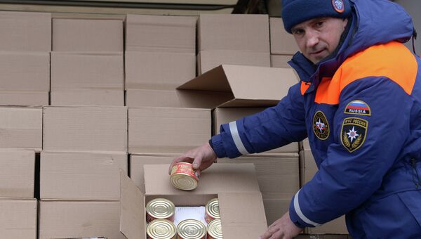 Сотрудник МЧС России демонстрирует банки с тушеной говядиной - гуманитарный груз одного из грузовых автомбилей шестнадцатого российского гуманитарного конвоя. Архивное фото Сотрудник МЧС России демонстрирует банки с тушеной говядиной - гуманитарный груз одного из грузовых автомбилей шестнадцатого российского гуманитарного конвоя. Архивное фото