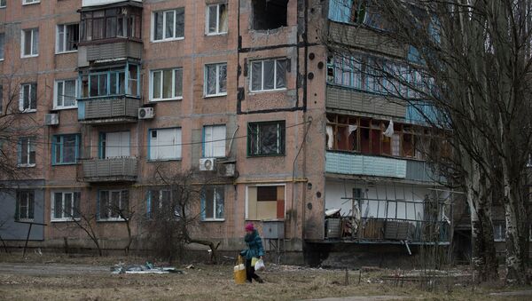 Женщина проходит мимо разрушенного жилого дома в Авдеевке, Украина. Архивное фто Женщина проходит мимо разрушенного жилого дома в Авдеевке, Украина. Архивное фто