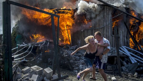 Местные жители спасаются от пожара, возникшего в результате авиационного удара вооруженных сил Украины по станице Луганская, 2 июля 2014 Местные жители спасаются от пожара, возникшего в результате авиационного удара вооруженных сил Украины по станице Луганская, 2 июля 2014
