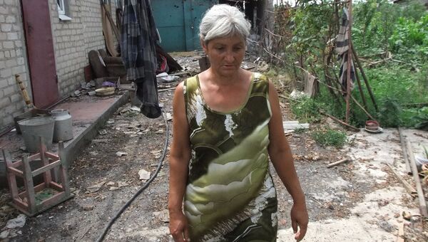 Женщина у дома, поврежденного в результате обстрела украинскими силовиками, в селе Саханка Донецкой области Женщина у дома, поврежденного в результате обстрела украинскими силовиками, в селе Саханка Донецкой области
