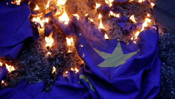 Демонстранцы жгут флаг на акции протеста против принятия проекта соглашения ЕС в Афинах. Архивное фото Демонстранцы жгут флаг на акции протеста против принятия проекта соглашения ЕС в Афинах. Архивное фото