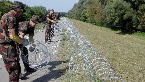 Военнослужащие венгерской армии устанавливают заграждения на границе с Хорватией, 18 сентября 2015. Архивное фото Военнослужащие венгерской армии устанавливают заграждения на границе с Хорватией, 18 сентября 2015. Архивное фото