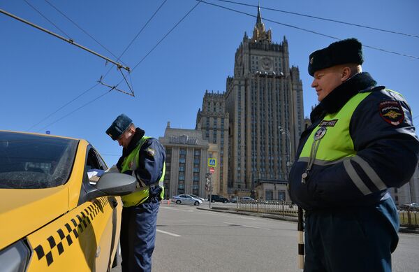 Сотрудники ГИБДД проверяют документы у водителя в рамках рейда против нелегальных таксистов в Москве Сотрудники ГИБДД проверяют документы у водителя в рамках рейда против нелегальных таксистов в Москве