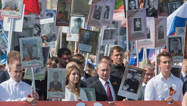 Президент России Владимир Путин с портретом своего отца-фронтовика Владимира Спиридоновича принимает участие в шествии патриотической акции Бессмертный полк Президент России Владимир Путин с портретом своего отца-фронтовика Владимира Спиридоновича принимает участие в шествии патриотической акции Бессмертный полк