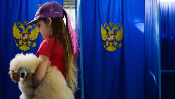 Девочка с собакой в единый день голосования на избирательном участке. Архивное фото Девочка с собакой в единый день голосования на избирательном участке. Архивное фото