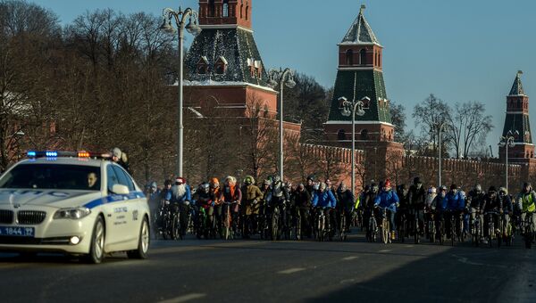Участники Второго зимнего Московского Велопарада в сопровождении машины сотрудников ДПС на Кремелвской набережой Участники Второго зимнего Московского Велопарада в сопровождении машины сотрудников ДПС на Кремелвской набережой