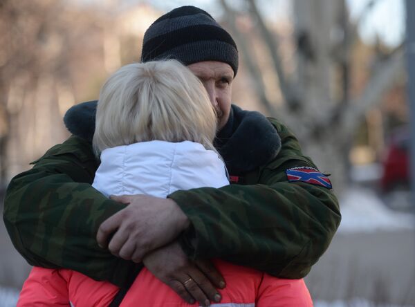Женщина прощается с ополченцем ДНР перед отправкой автобусов с беженцами из Донецка в Россию Женщина прощается с ополченцем ДНР перед отправкой автобусов с беженцами из Донецка в Россию