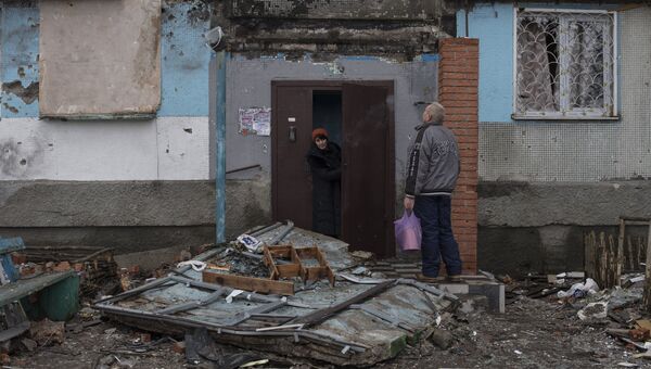Жители Донецка у подъезда дома, поврежденного в результате обстрелов Жители Донецка у подъезда дома, поврежденного в результате обстрелов