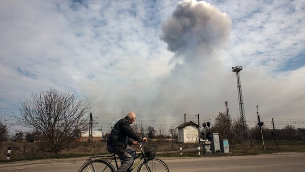 Мужчина на велосипеде на одной из улиц города Балаклея в Харьковской области во время пожара на военных складах боеприпасов Мужчина на велосипеде на одной из улиц города Балаклея в Харьковской области во время пожара на военных складах боеприпасов