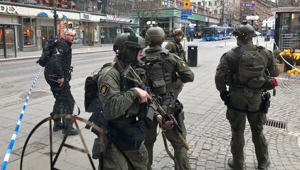 Полицейские в центре Стокгольма после наезда грузовика на людей на улице Дроттнинггатан. 7 апреля 2017 Полицейские в центре Стокгольма после наезда грузовика на людей на улице Дроттнинггатан. 7 апреля 2017