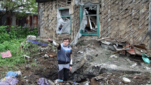 Подросток демонстрирует повреждения жилого дома, полученные в результате обстрела. Архивное фото Подросток демонстрирует повреждения жилого дома, полученные в результате обстрела. Архивное фото