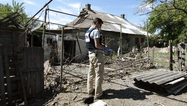 Сотрудник ОБСЕ осматривает двор жилого дома, пострадавший в результате обстрела Докучаевска в Донецкой области. Архивное фото Сотрудник ОБСЕ осматривает двор жилого дома, пострадавший в результате обстрела Докучаевска в Донецкой области. Архивное фото