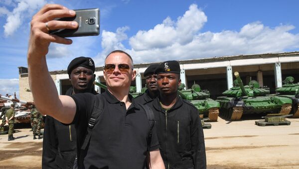Посетитель фотографируется с участниками команды Зимбабве перед началом репетиции международного этапа конкурса Танковый биатлон Армейских международных игр -2017 в Алабино Посетитель фотографируется с участниками команды Зимбабве перед началом репетиции международного этапа конкурса Танковый биатлон Армейских международных игр -2017 в Алабино