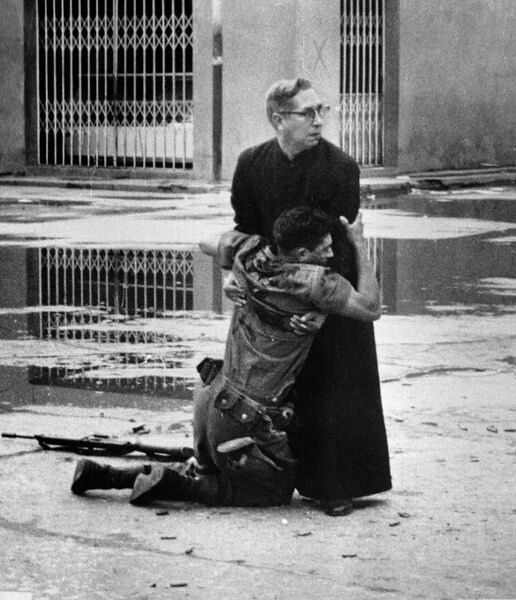 Священник Луис Падильо и солдат, раненый снайпером, во время восстания в Венесуэле. 1962 год Священник Луис Падильо и солдат, раненый снайпером, во время восстания в Венесуэле. 1962 год