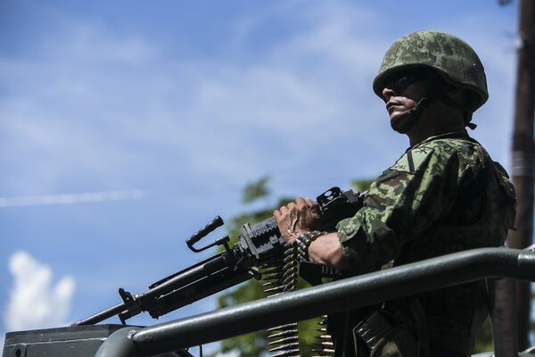 Солдат во время перевозки тел военных, убитых накануне в результате нападения, в Кульякане, Мексика Солдат во время перевозки тел военных, убитых накануне в результате нападения, в Кульякане, Мексика