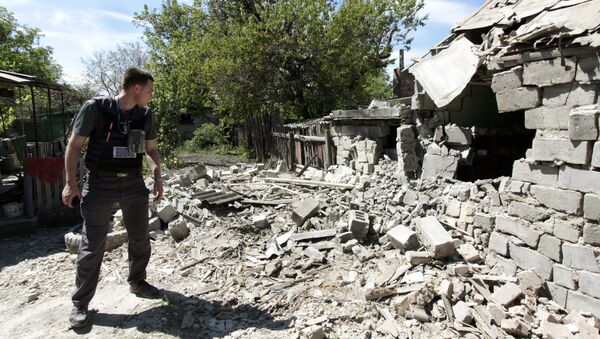 Сотрудник ОБСЕ осматривает двор жилого дома, пострадавший в результате обстрела Докучаевска в Донецкой области. Архивное фото Сотрудник ОБСЕ осматривает двор жилого дома, пострадавший в результате обстрела Докучаевска в Донецкой области. Архивное фото