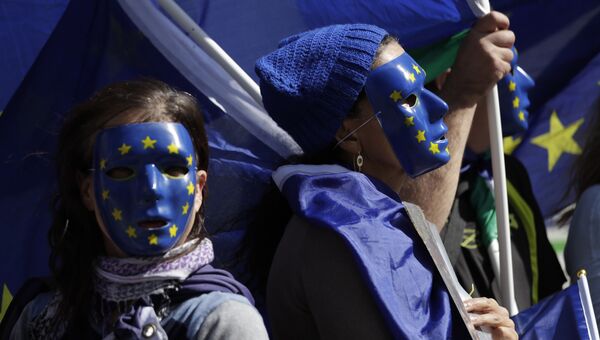 Участники акции протеста против Brexit в масках, стилизованных под флаг Евросоюза, в Лондоне Участники акции протеста против Brexit в масках, стилизованных под флаг Евросоюза, в Лондоне