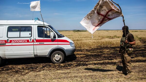 Украинский военный с белым флагом во время передачи убитых на нейтральной территории вблизи поселка Диброво возле российско-украинской границы в Донецкой области Украинский военный с белым флагом во время передачи убитых на нейтральной территории вблизи поселка Диброво возле российско-украинской границы в Донецкой области