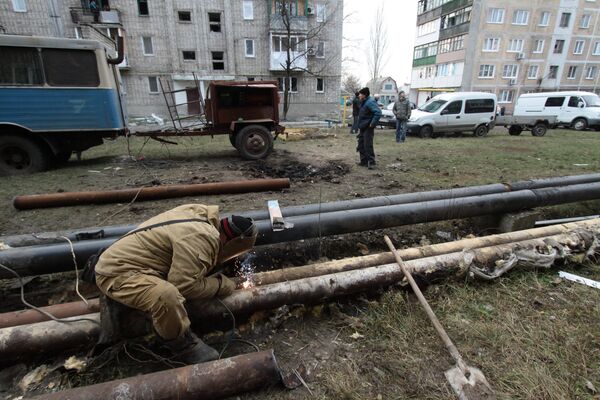 Сотрудник ЖКХ ремонтирует трубы жилого дома в городе Ясиноватая, пострадавшего в результате обстрела. 21 декабря 2017 Сотрудник ЖКХ ремонтирует трубы жилого дома в городе Ясиноватая, пострадавшего в результате обстрела. 21 декабря 2017